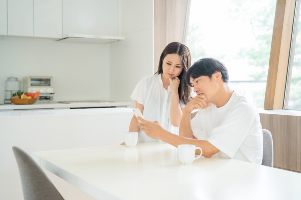 子役活動の後悔ポイントを相談しながらスマホで検索する夫婦の様子